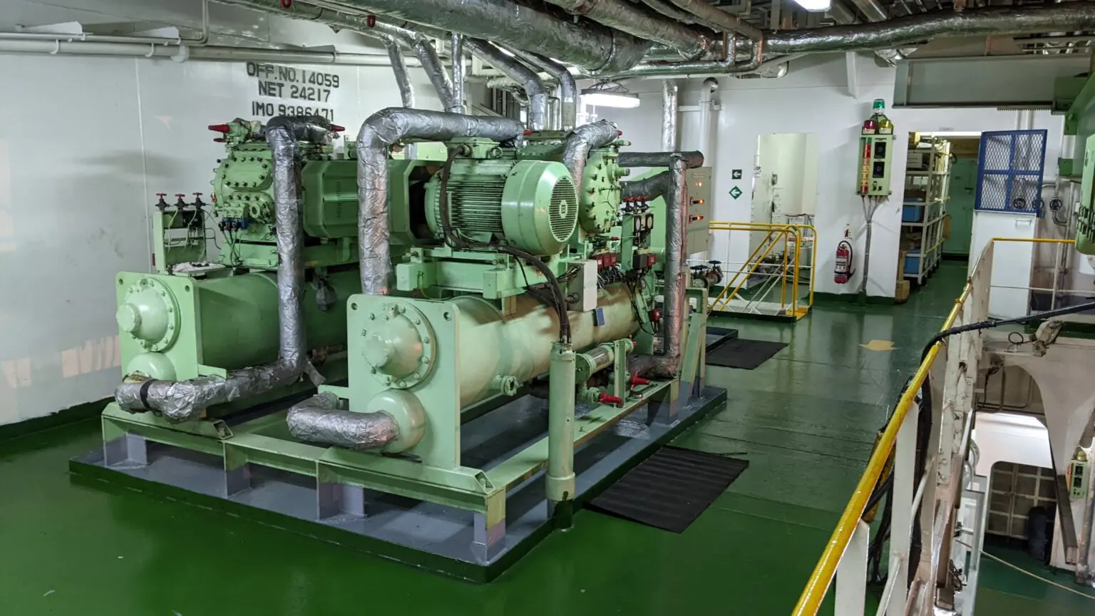 A green and white ship with pipes on the floor