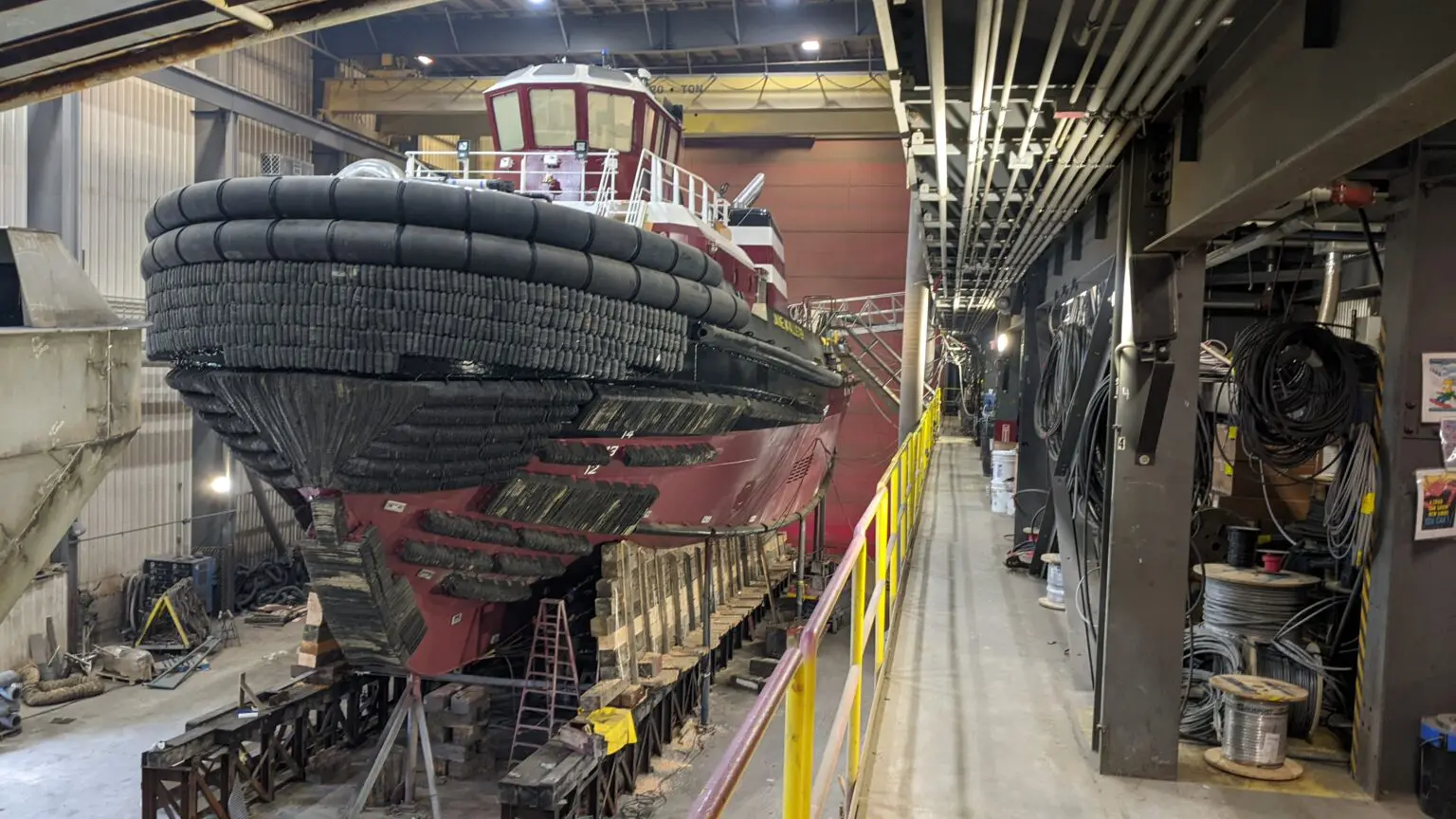 A large boat is being worked on in the shop.
