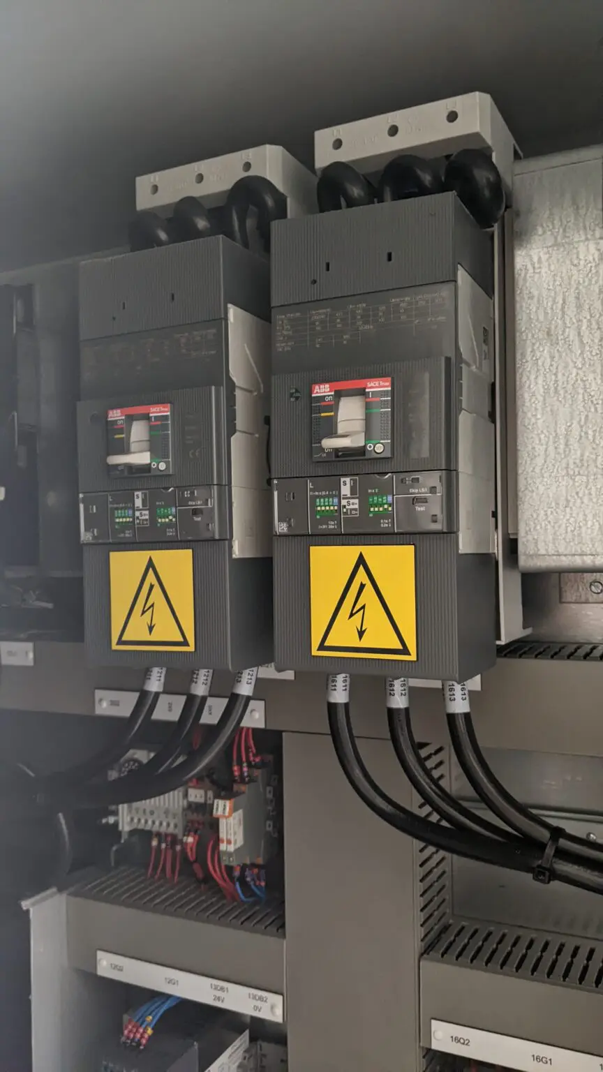 A couple of electrical boxes hanging from wires.