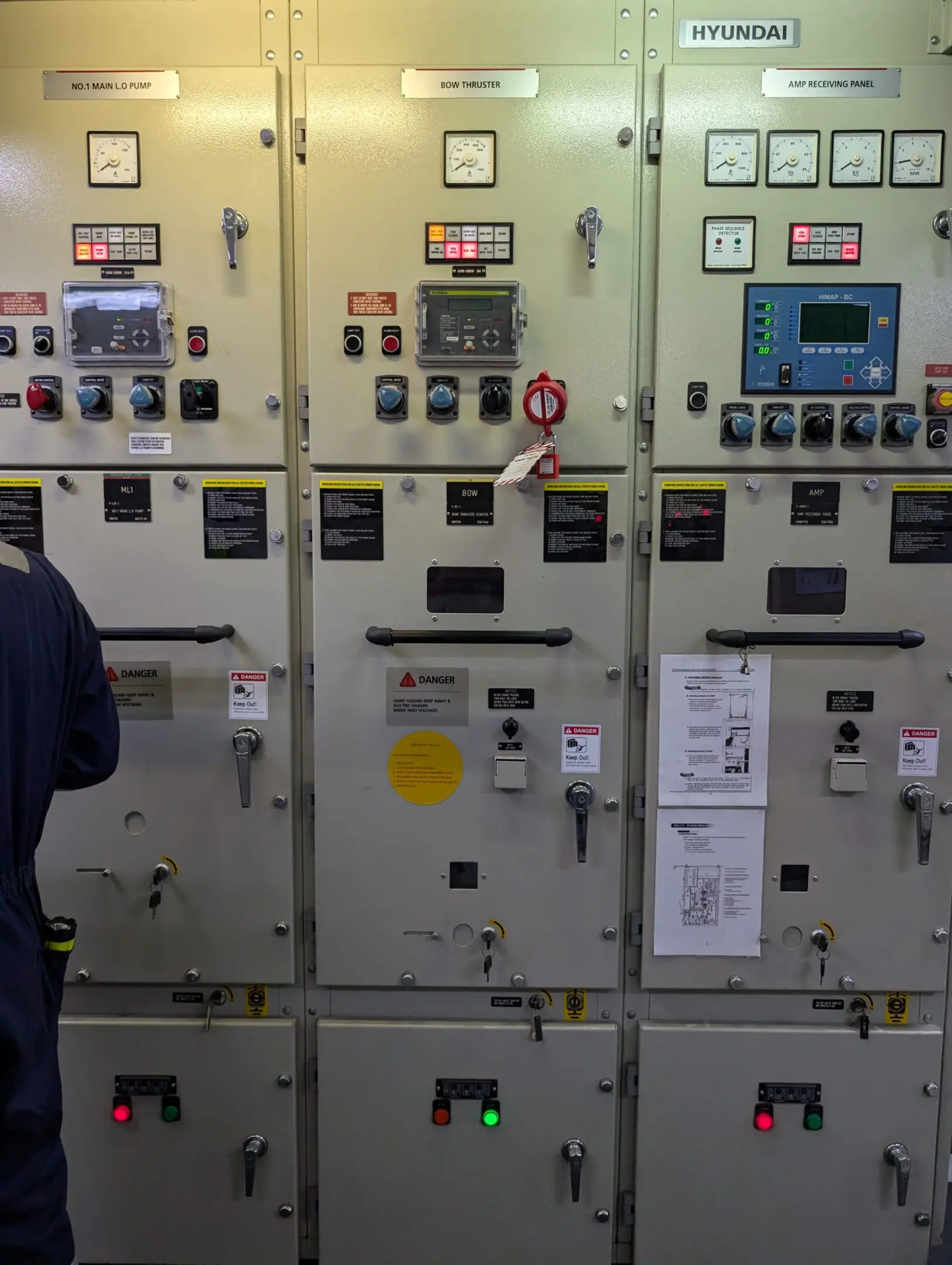 PXL_20240716_142051490 A man standing in front of many electrical panels.