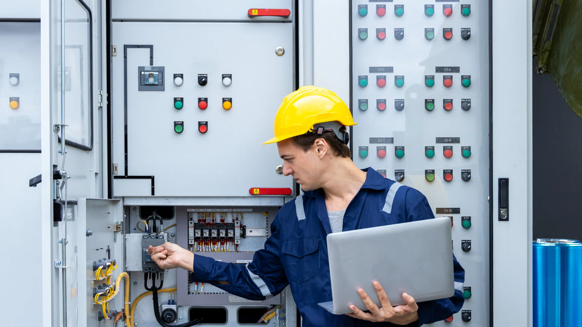 GettyImages-1416468815 Engineer inspecting electrical control panel.