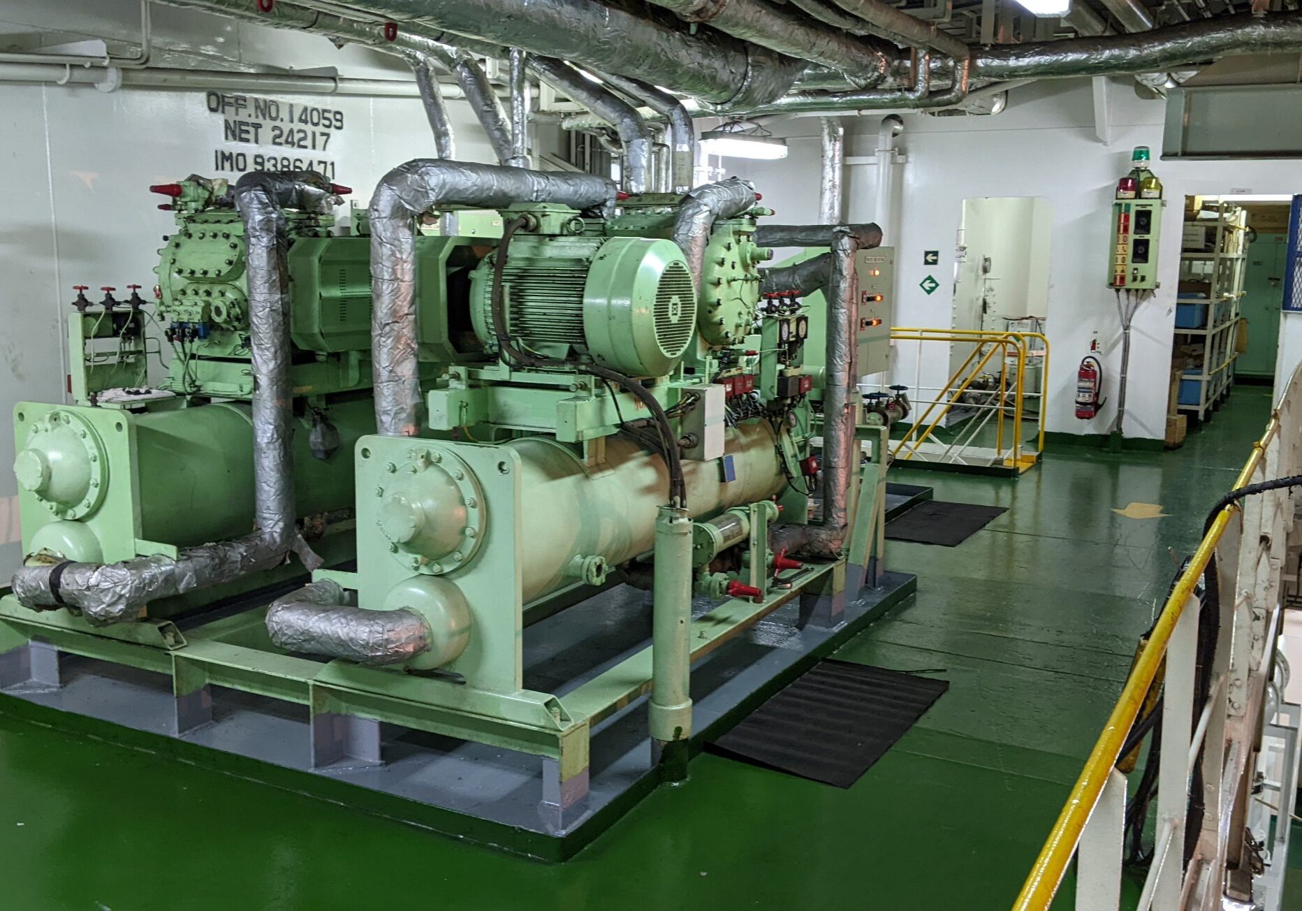 A green and white ship with pipes on the floor